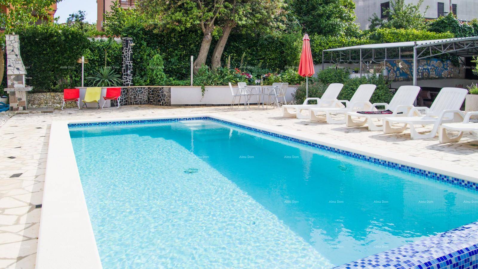 Langer, rechteckiger Pool mit blauen Mosaikfliesen und Sonnenliegen auf der Terrasse.