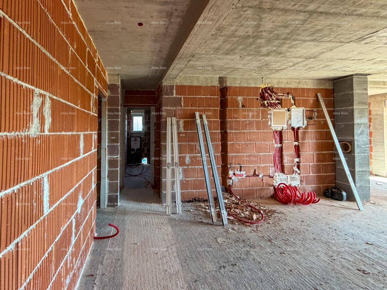 Innenraum im Rohbau mit unverputzten Ziegelwänden und sichtbaren Elektroinstallationen.
