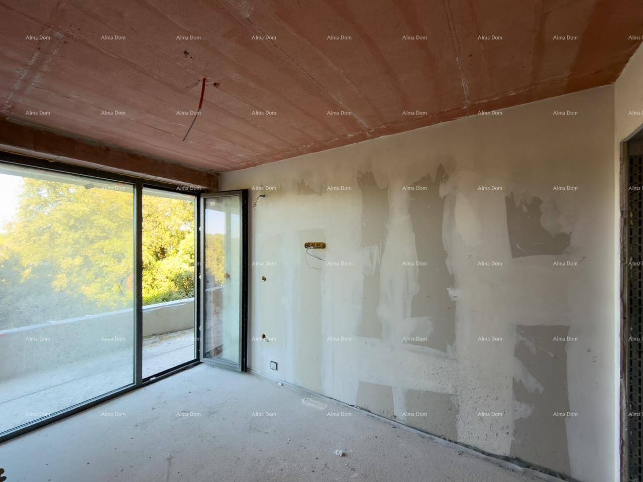 Heller Innenraum im Rohbau mit großen Fenstern und Zugang zu einem potenziellen Außenbereich.