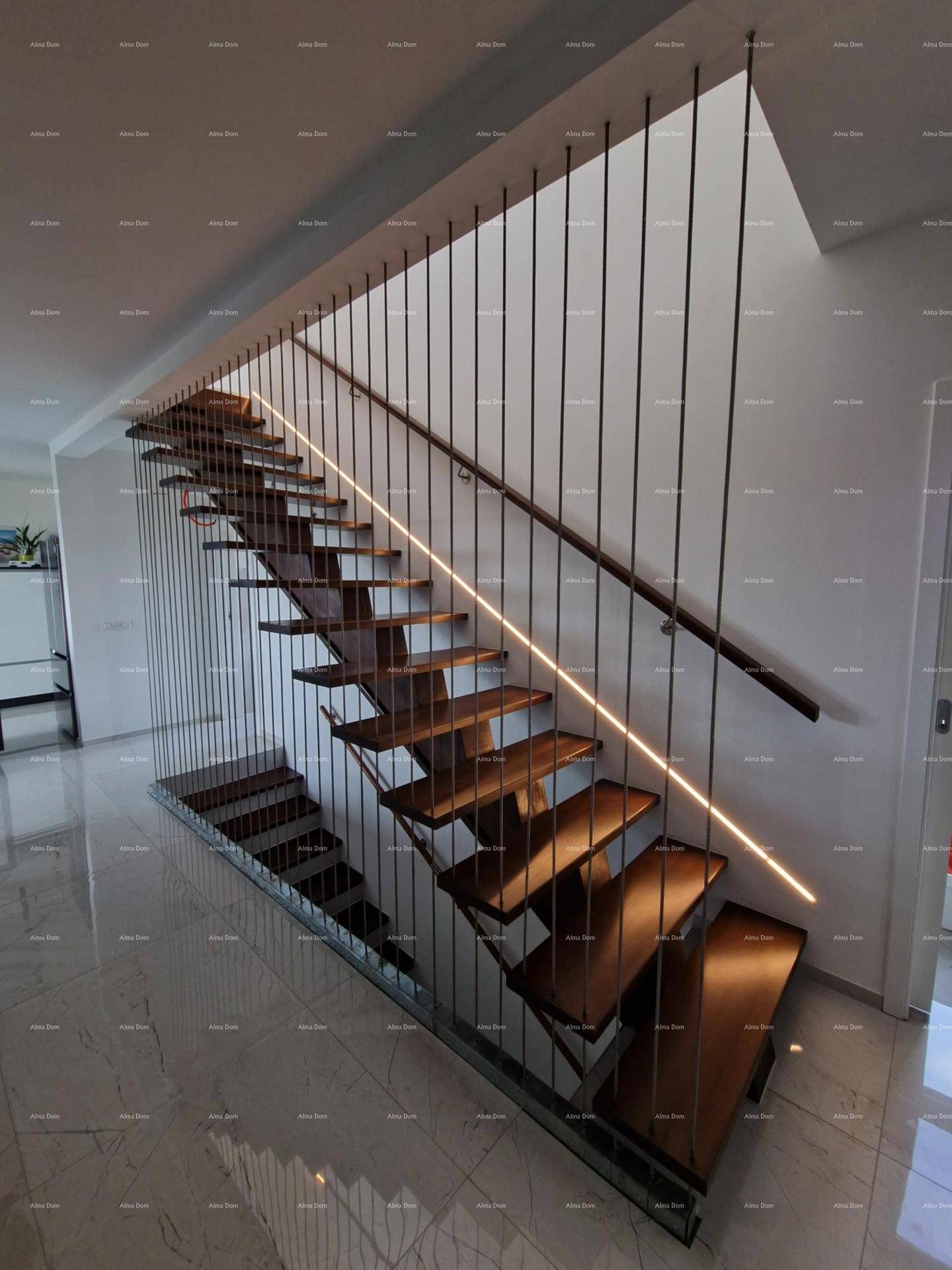 Moderne Holztreppe mit filigranem Geländer und integrierter Beleuchtung.