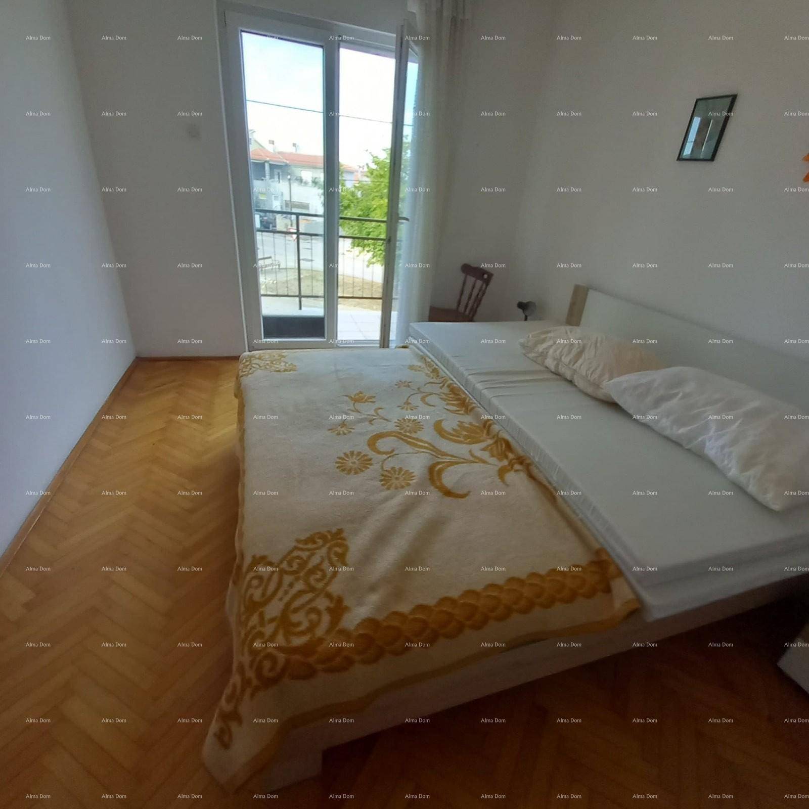 Schlafzimmer mit Parkettboden und Zugang zu einem Balkon, der viel Tageslicht bietet.