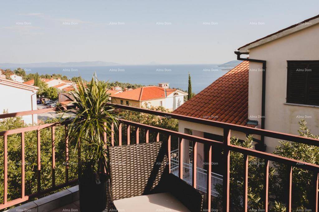 Balkon mit Meerblick, ausgestattet mit einer Pflanze und einem Korbstuhl, um die Aussicht zu genießen.