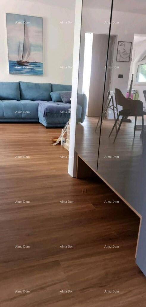 Heller Wohnbereich mit blauem Sofa, Holzboden und einem großen Spiegel, der den Raum erweitert.