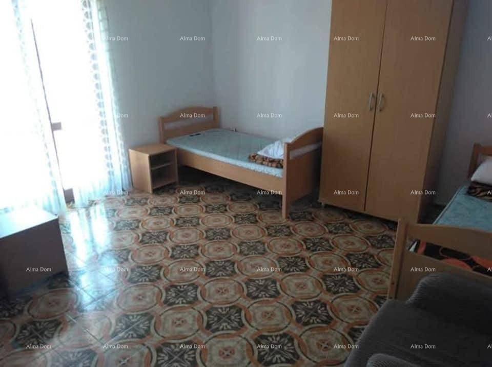 Schlafzimmer mit zwei Einzelbetten, Kleiderschrank und auffälligem Fliesenboden.