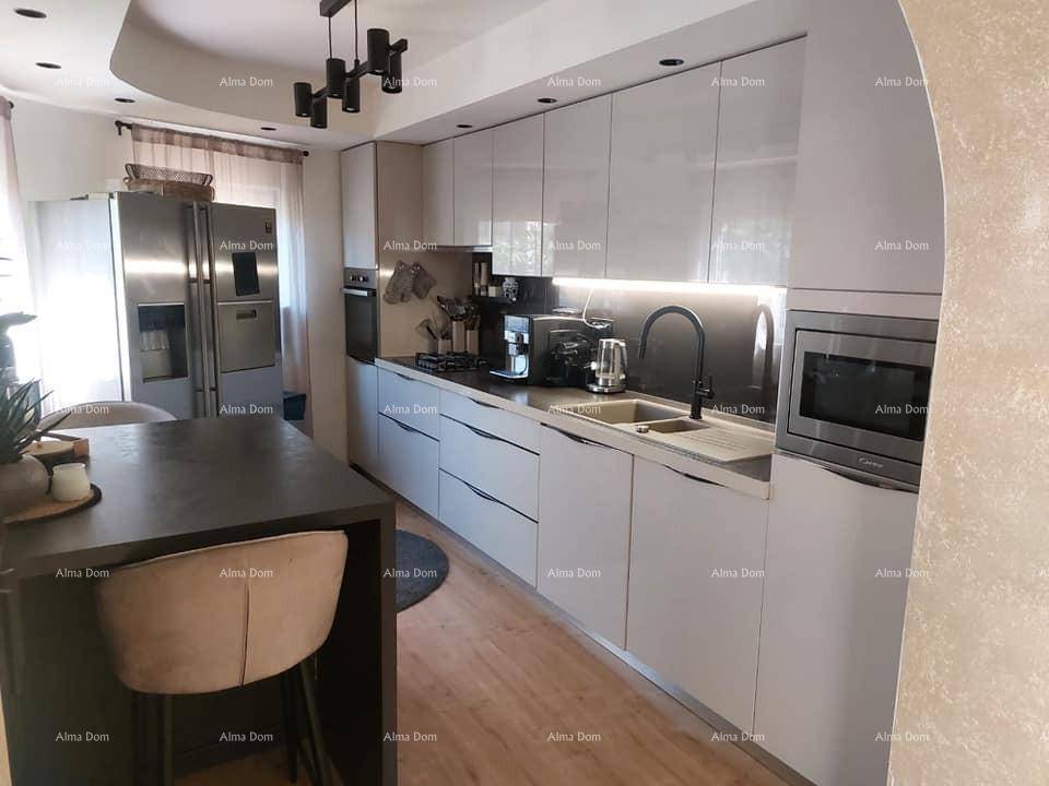 Moderne Küche mit weißen Hochglanzfronten, integrierten Geräten und einer Kücheninsel mit Barhockern.