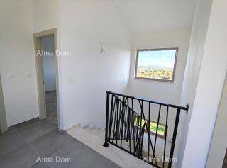 Heller Treppenaufgang mit modernem Geländer und Fenster mit Ausblick.