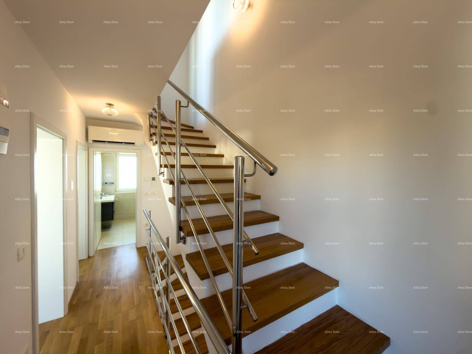 Heller Flur mit moderner Holztreppe und Edelstahlgeländer, führt zu weiteren Räumen.
