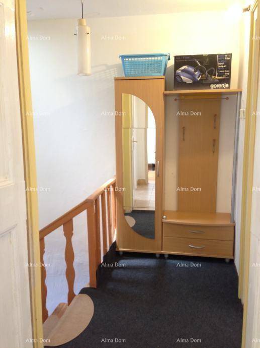 Flur mit Garderobe, Spiegel und Treppenaufgang.