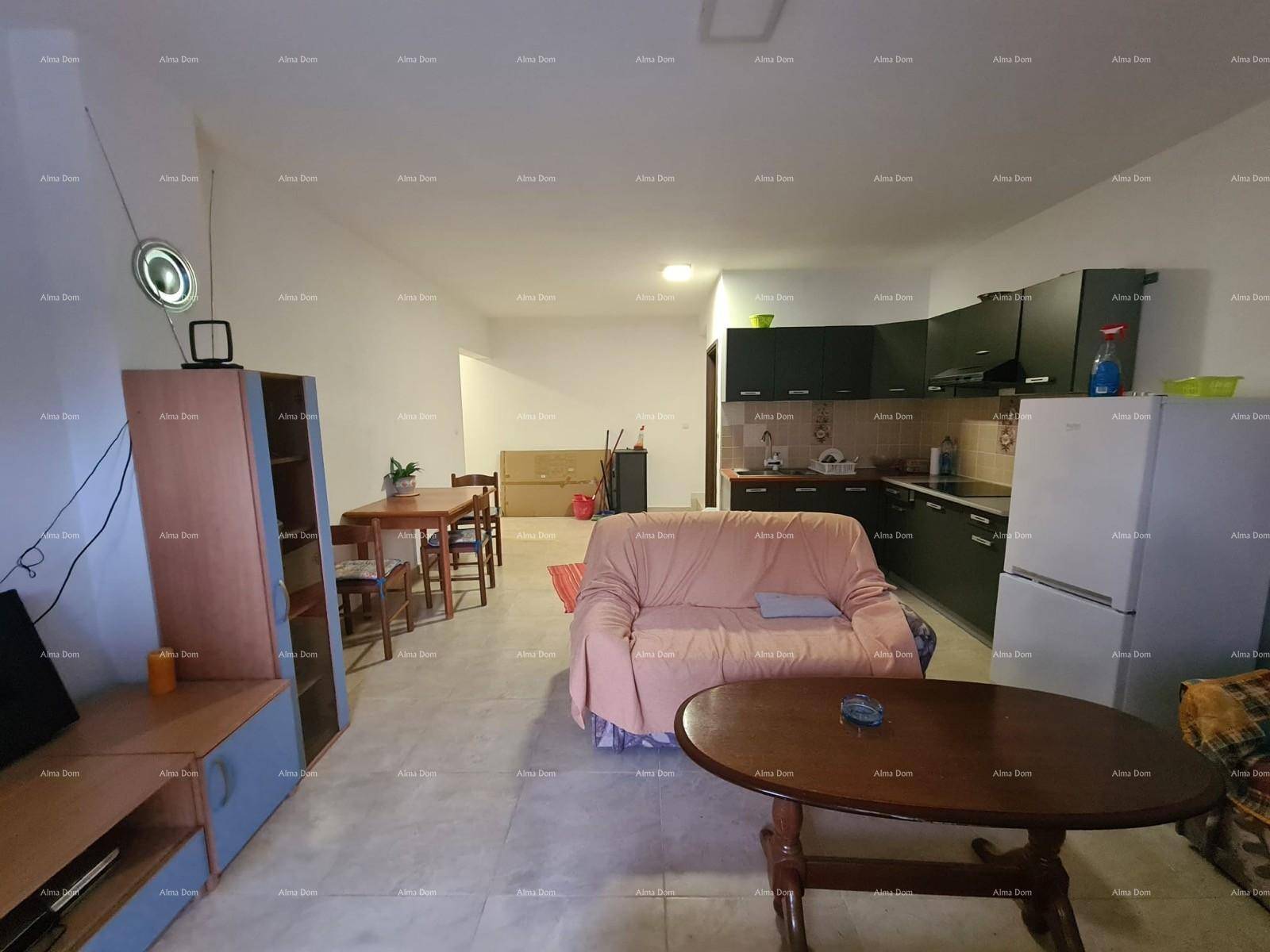 Geräumiger Wohn-Essbereich mit offener Küche, Sofa und Esstisch auf Fliesenboden.