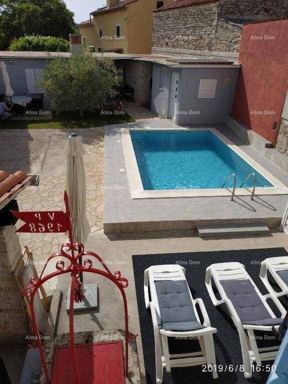 Vogelperspektive des Anwesens mit Pool, Liegestühlen und dem charmanten Steinhaus.