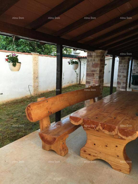 Überdachte Terrasse mit rustikalen Holzbänken und Esstisch im Freien.