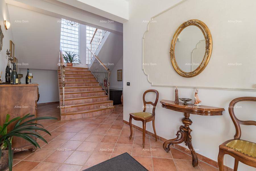Geräumiger Flur mit Terrakottafliesen, eleganter Treppe und klassischer Einrichtung, die zum Obergeschoss führt.