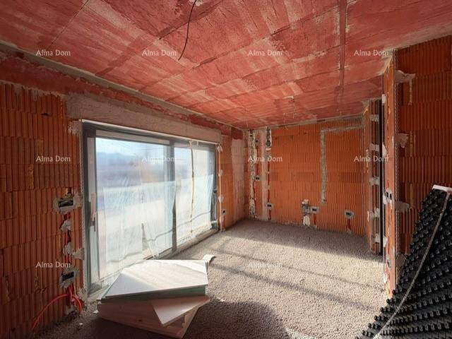 Innenraum im Rohbau mit Ziegelwänden, Estrichboden und großen Fenstern.
