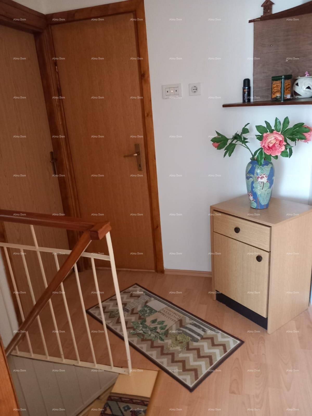 Heller Flur mit Holztüren und Treppengeländer, auf einem Laminatboden.