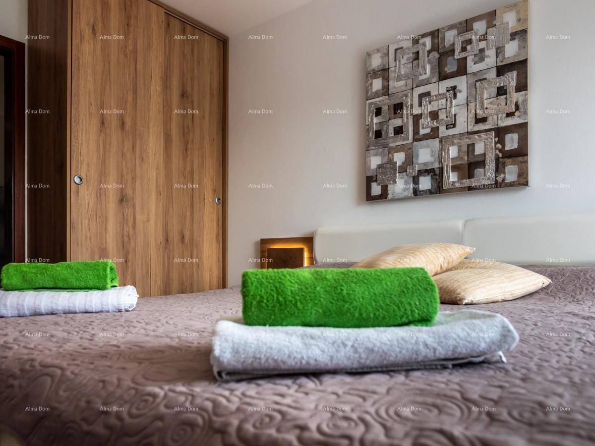 Gemütliches Doppelbett mit frischen Handtüchern und modernem Kunstwerk im Hintergrund.