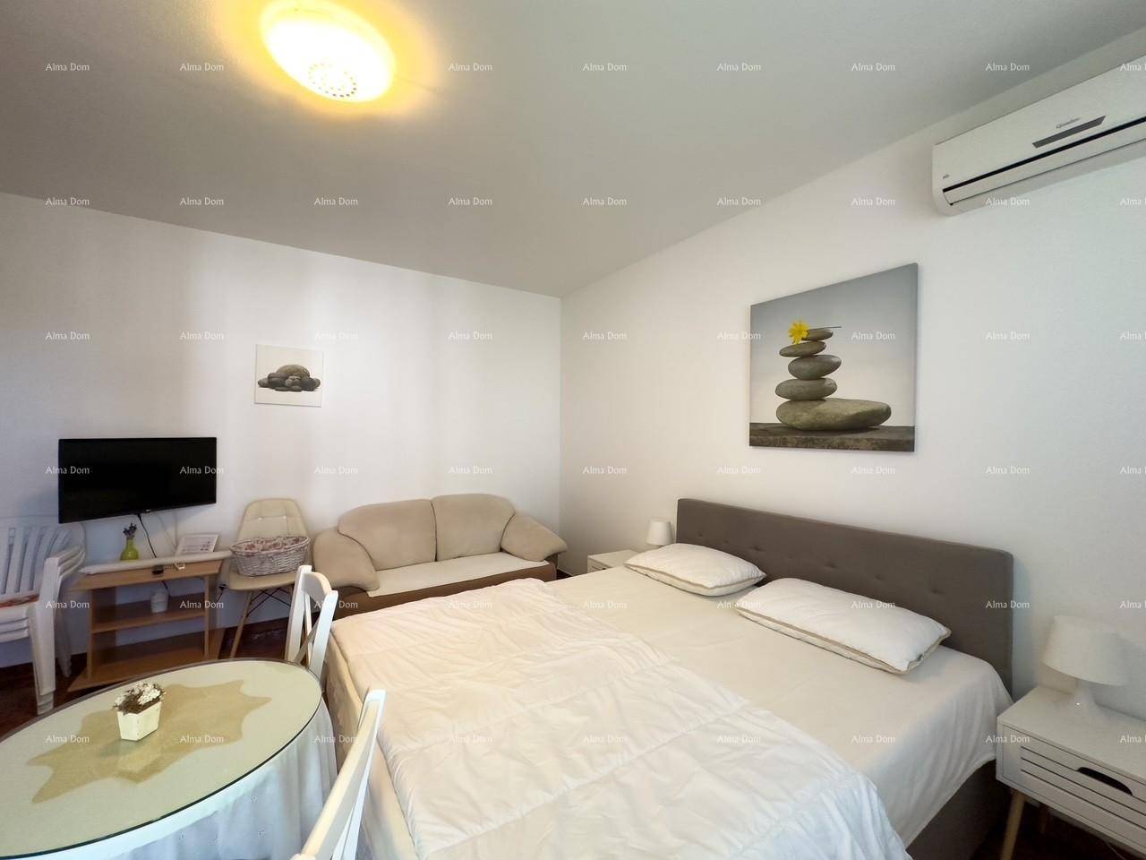 Helles Schlafzimmer mit Doppelbett und Klimaanlage, dekoriert mit beruhigenden Steinbildern.