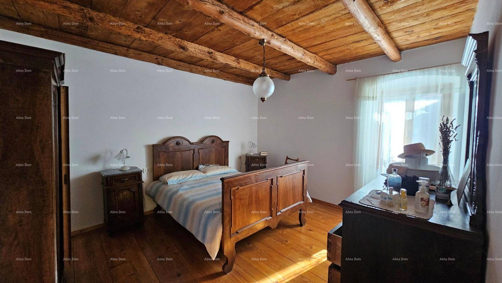 Gemütliches Schlafzimmer mit Holzbalkendecke, Dielenboden und traditionellem Holzmöbel.