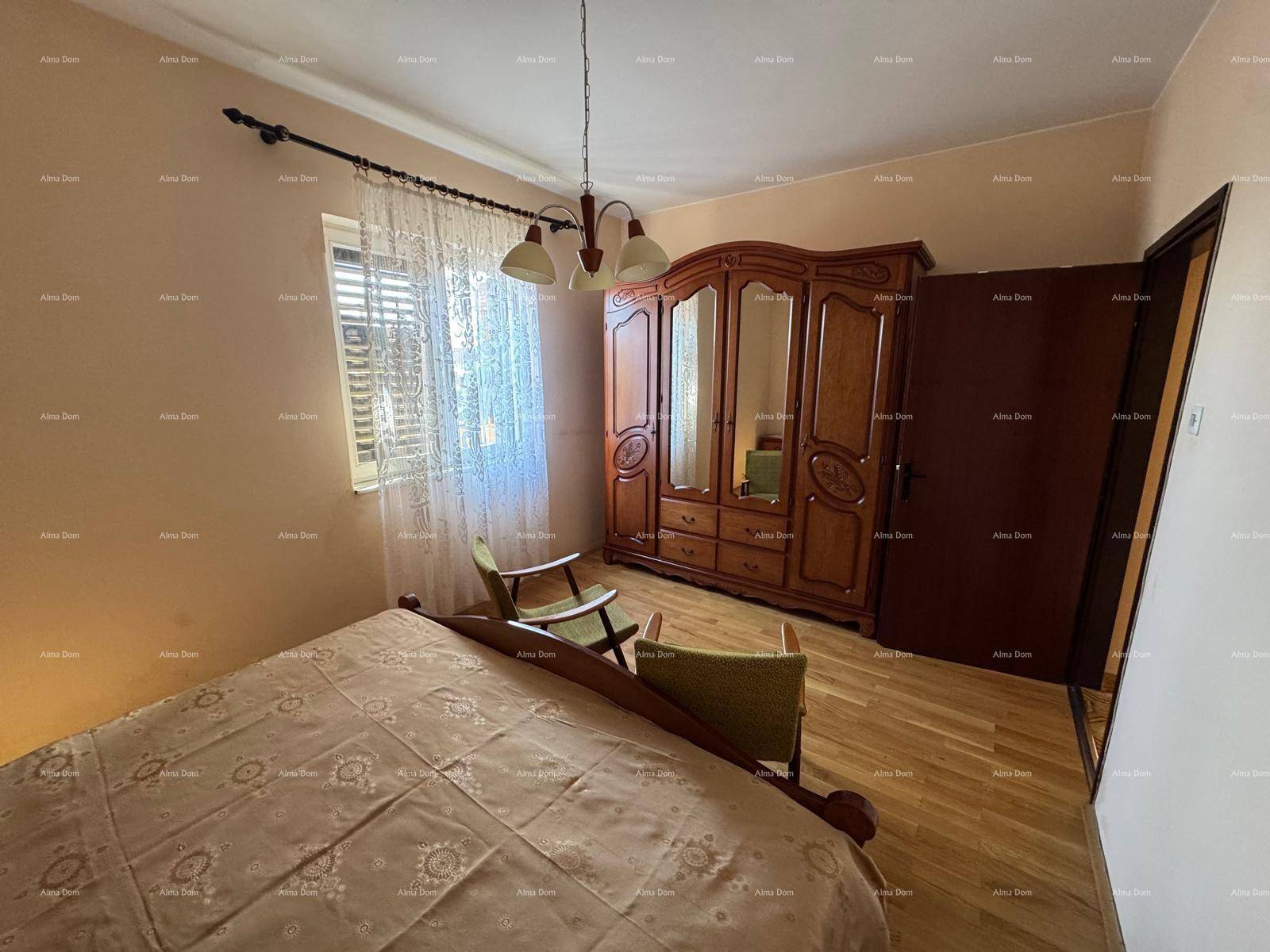 Schlafzimmer mit Doppelbett, Holzschrank und Parkettboden, hell und gemütlich.