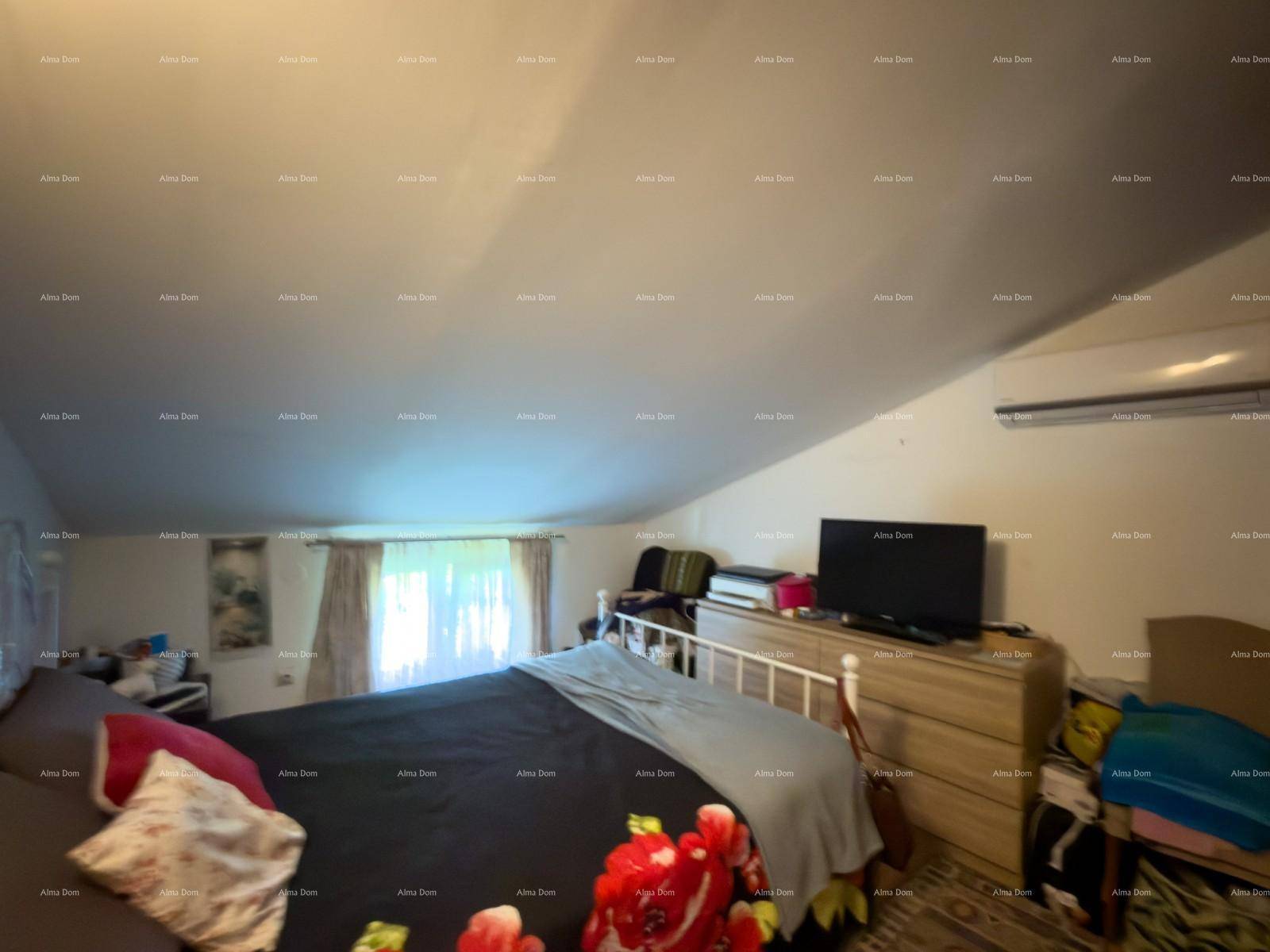 Helles Schlafzimmer mit schräger Decke, Doppelbett und Klimaanlage, bietet eine gemütliche Atmosphäre.