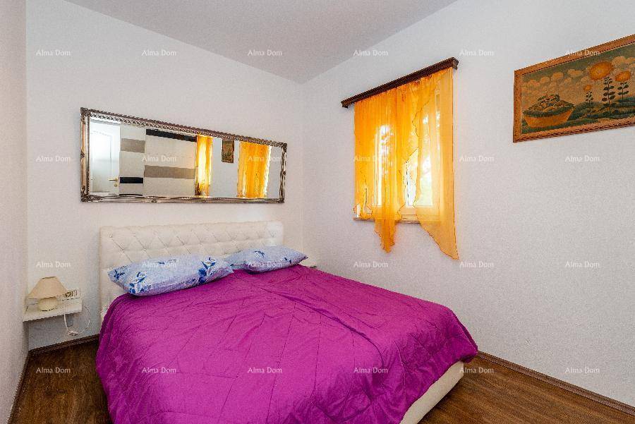 Schlafzimmer mit Doppelbett, großem Spiegel und farbenfrohen Vorhängen in Orange.