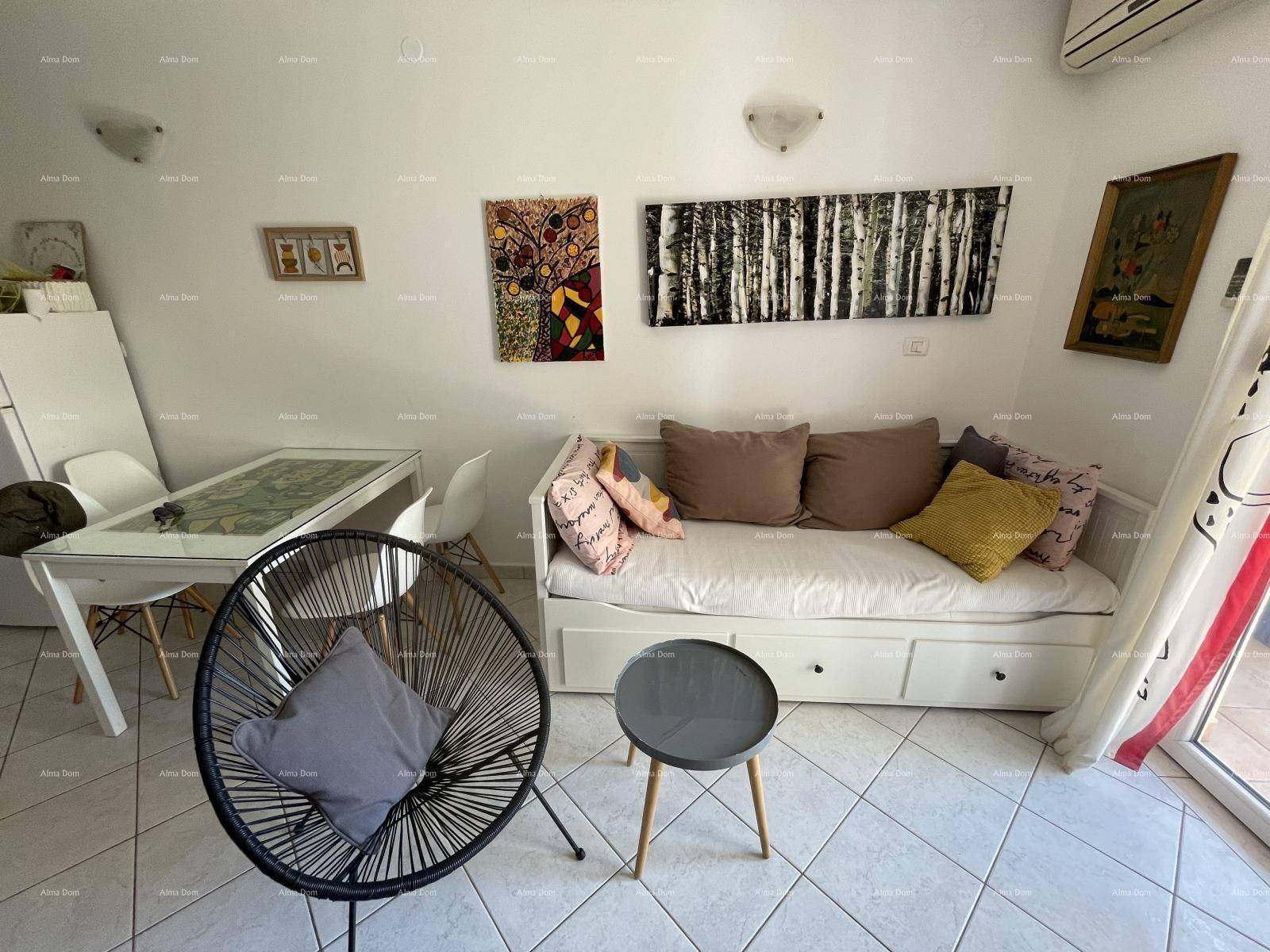 Gemütlicher Wohnbereich mit Schlafsofa, Esstisch und modernen Kunstwerken an den Wänden.