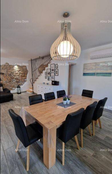 Eleganter Essbereich mit großem Holztisch, schwarzen Stühlen und moderner Hängelampe.