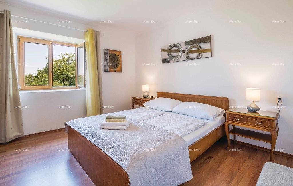 Helles Schlafzimmer mit Holzboden, Doppelbett und Fenster mit Blick ins Grüne.