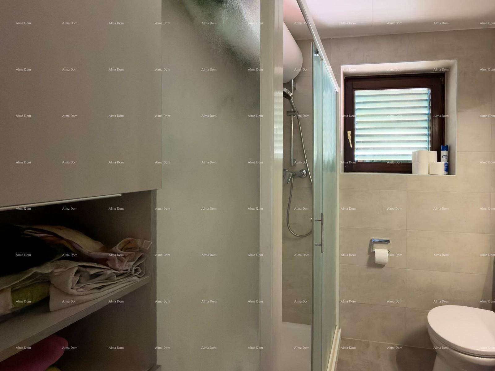 Modernes Badezimmer mit Duschkabine, WC und praktischen Ablageflächen.