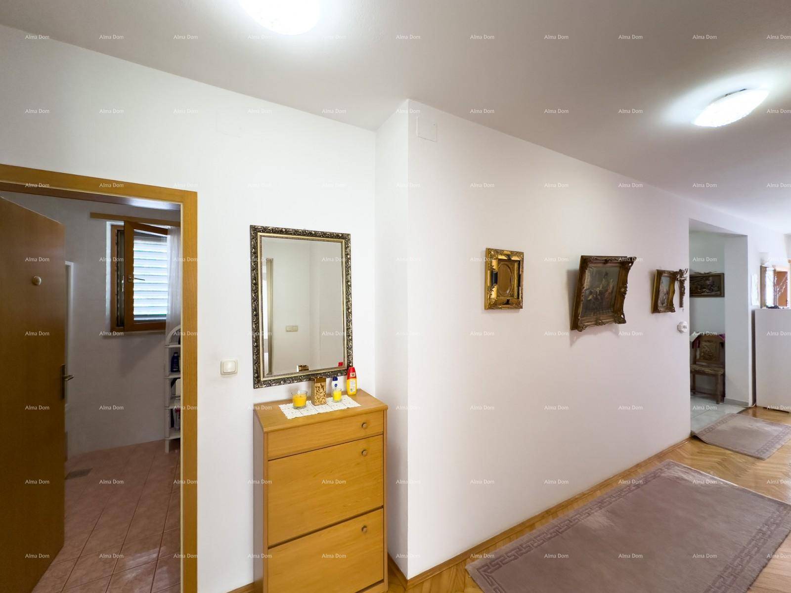 Heller Flur mit Holzkommode, Spiegel und Bildern an der Wand.