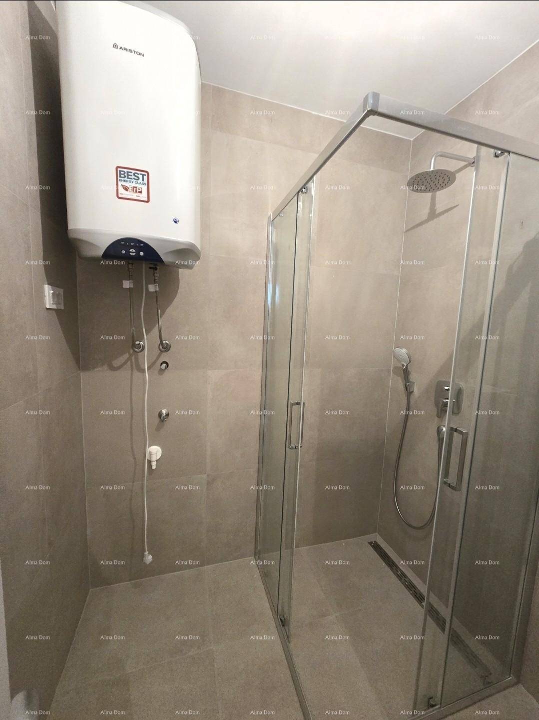 Badezimmer mit moderner Duschkabine aus Glas und wandmontiertem Warmwasserbereiter.
