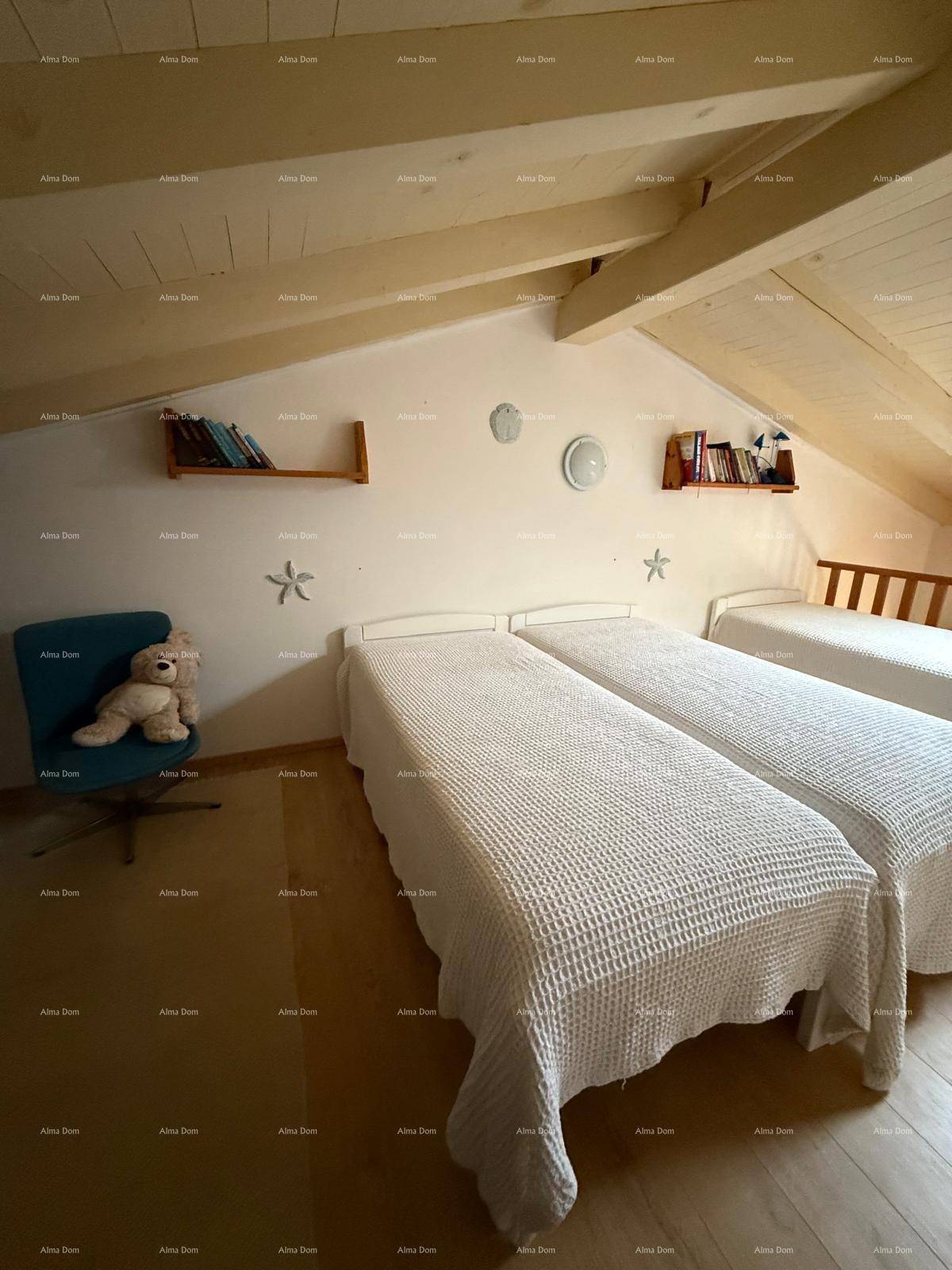 Dachgeschoss-Schlafzimmer mit Holzbalkendecke, Holzboden und maritimer Dekoration.