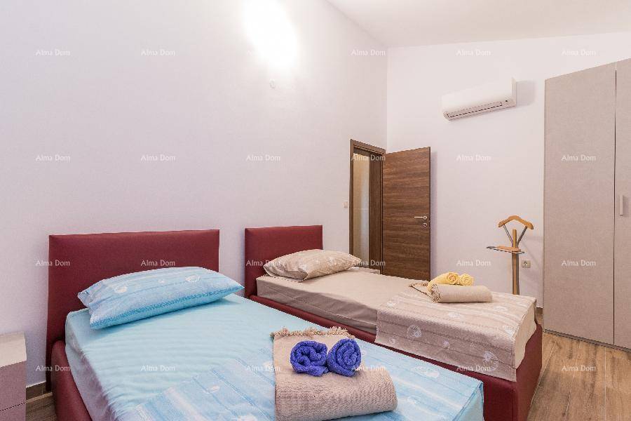 Schlafzimmer mit zwei Einzelbetten, Klimaanlage und einem Kleiderschrank.