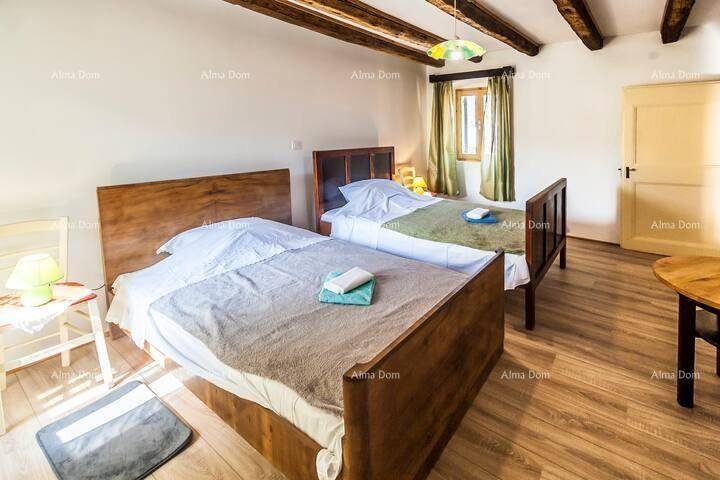 Helles Schlafzimmer mit zwei Einzelbetten, Holzbalkendecke und warmem Holzboden.