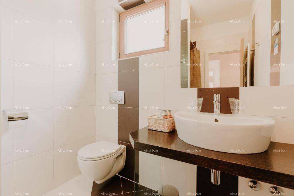 Modernes Badezimmer mit WC, Waschbecken und Fenster, ausgestattet mit weißen und braunen Fliesen.