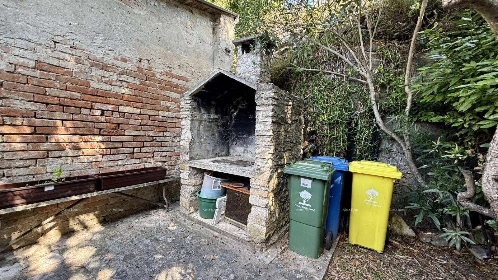 Gemauerter Grillplatz im Freien neben einer Ziegelwand, perfekt für sommerliche Grillabende.