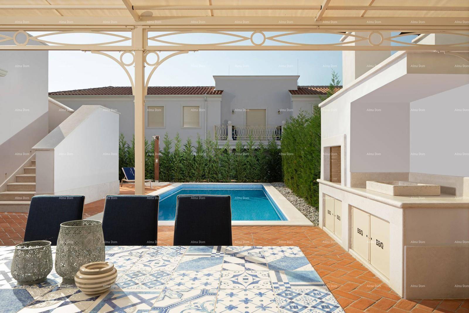 Überdachter Essbereich im Freien mit Grillstation und Blick auf den Pool und die Villa.