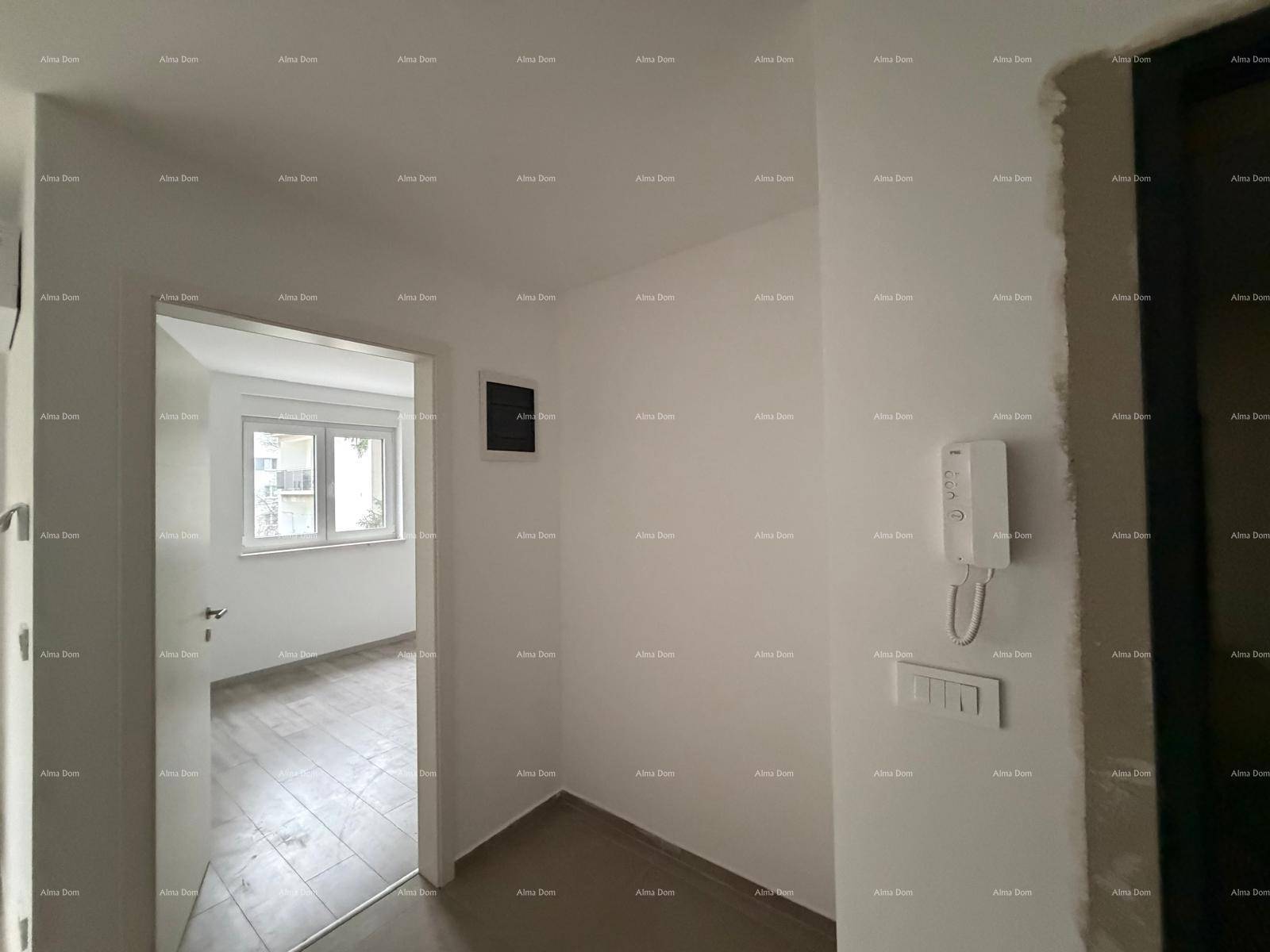 Unfertiger Flur oder Eingangsbereich mit Gegensprechanlage und Blick in einen weiteren Raum.