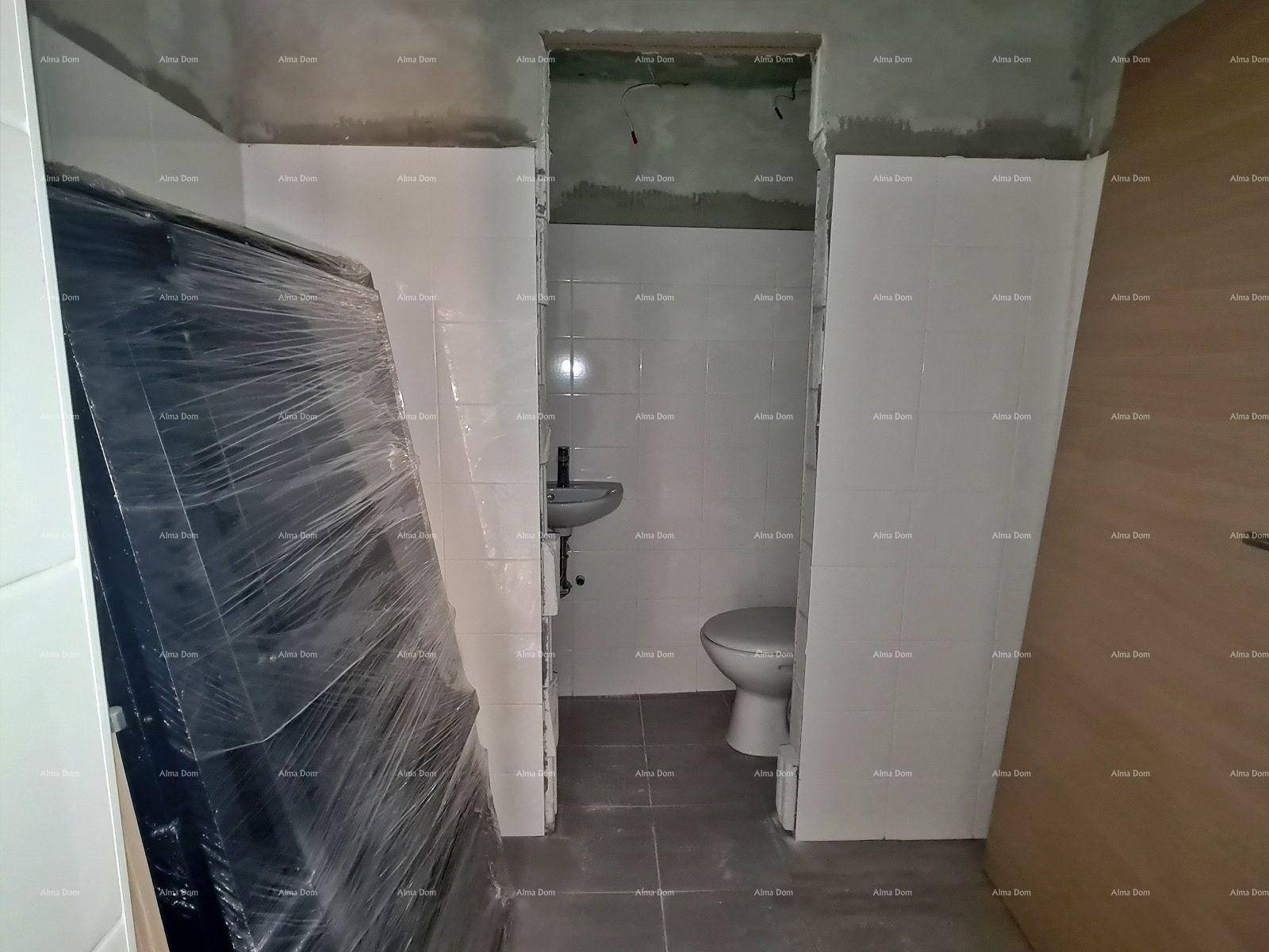 Teilweise fertiggestelltes Badezimmer mit Toilette, Waschbecken und gefliesten Wänden.