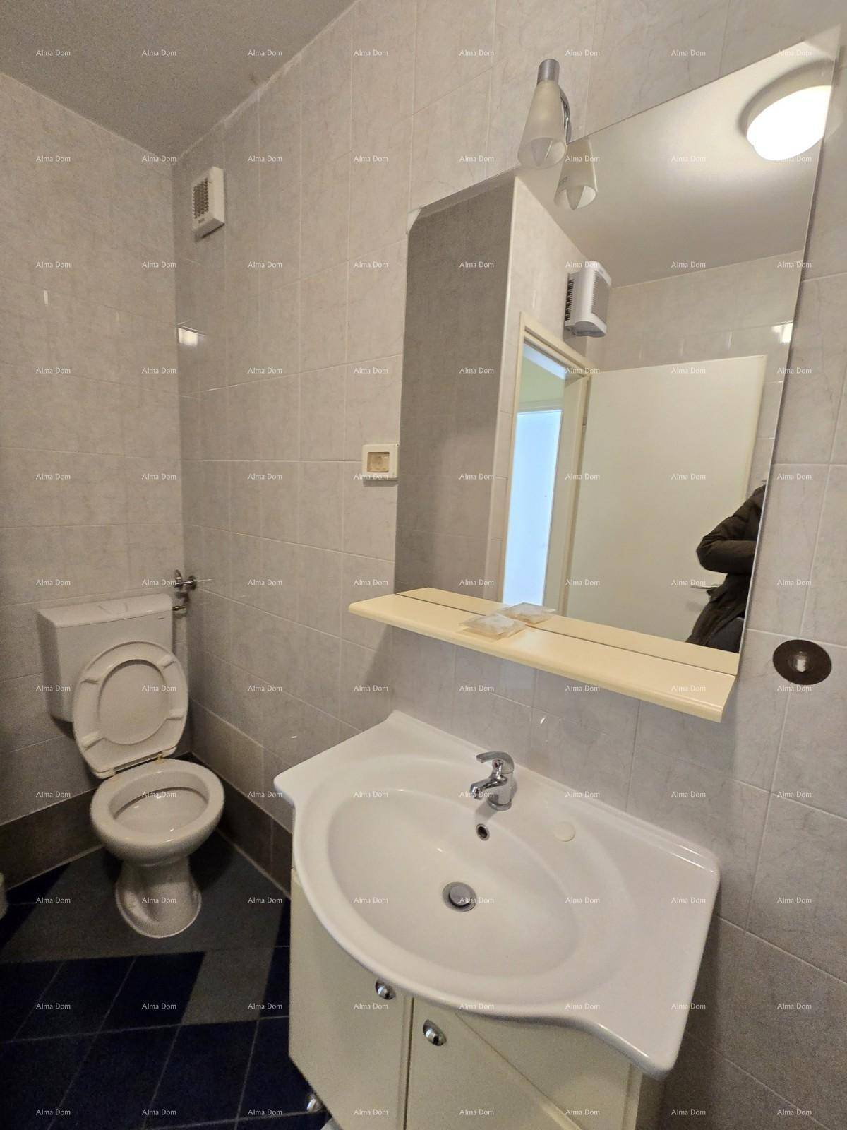 Badezimmer mit WC, Waschbecken und großem Spiegel, gefliest in hellen Tönen für eine saubere Optik.
