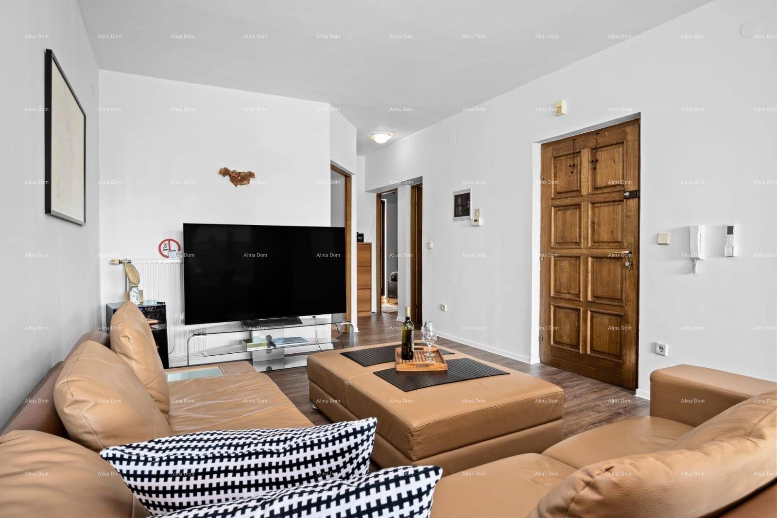 Gemütliches Wohnzimmer mit beigem Sofa, Fernseher und Holztür, bietet einen einladenden Rückzugsort.