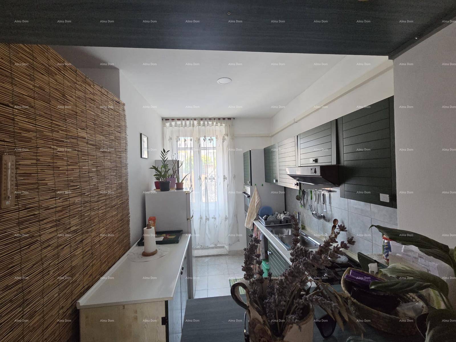 Küchenbereich mit Kühlschrank und Fenster, ergänzt durch eine dekorative Bambuswand.