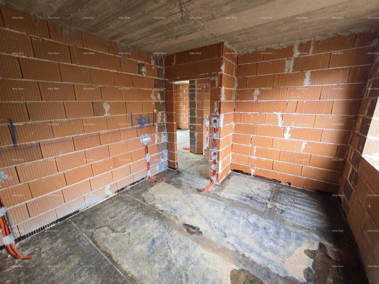 Innenraum im Rohbau mit Ziegelwänden, Türöffnung und vorbereiteten Elektroinstallationen.