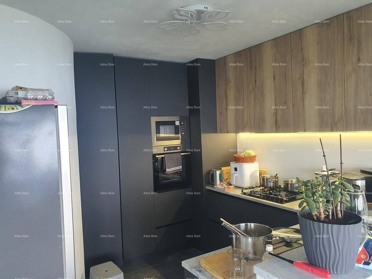Moderne Küche mit dunklen und holzfarbenen Schränken, ausgestattet mit Einbaugeräten.