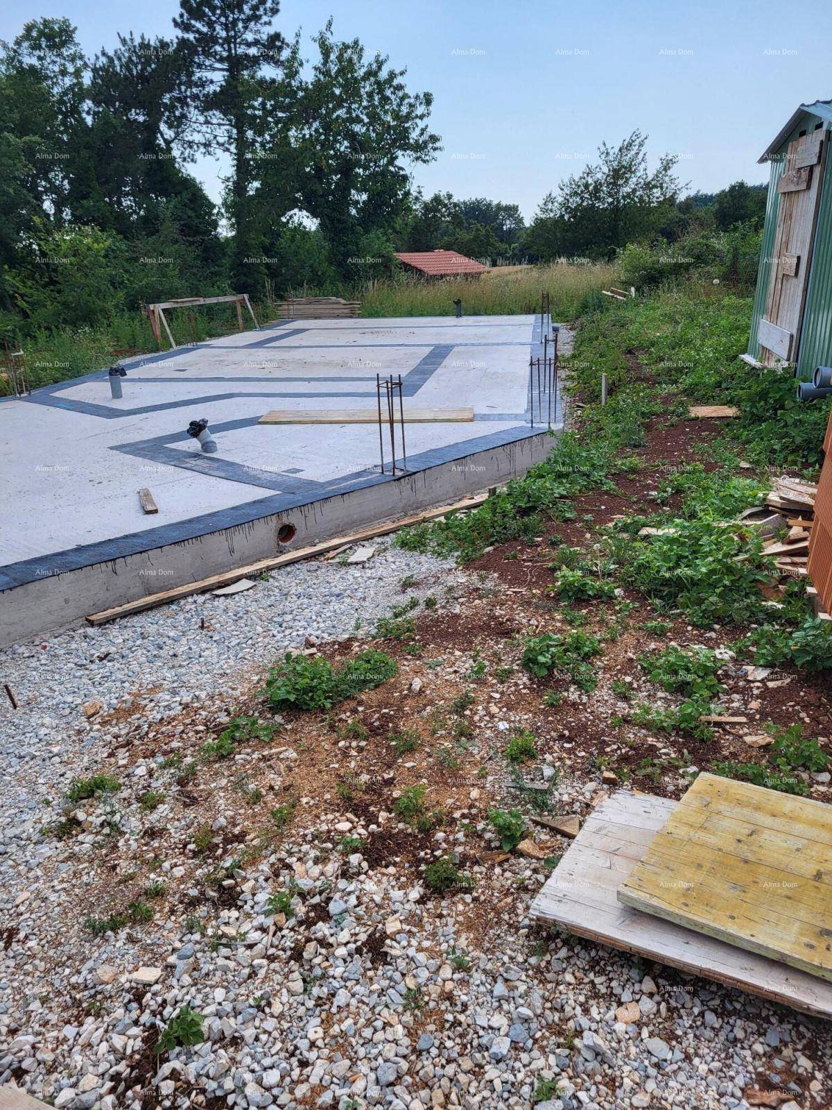 Baustelle mit frisch gegossenem Fundament und vorbereiteten Bewehrungsstäben für den Neubau.
