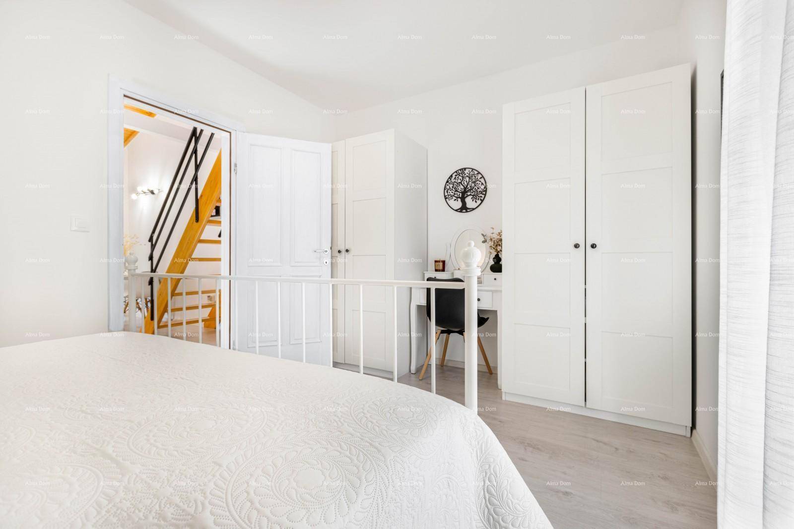 Schlafzimmer mit weißem Kleiderschrank, Schminktisch und Zugang zu einem weiteren Raum.