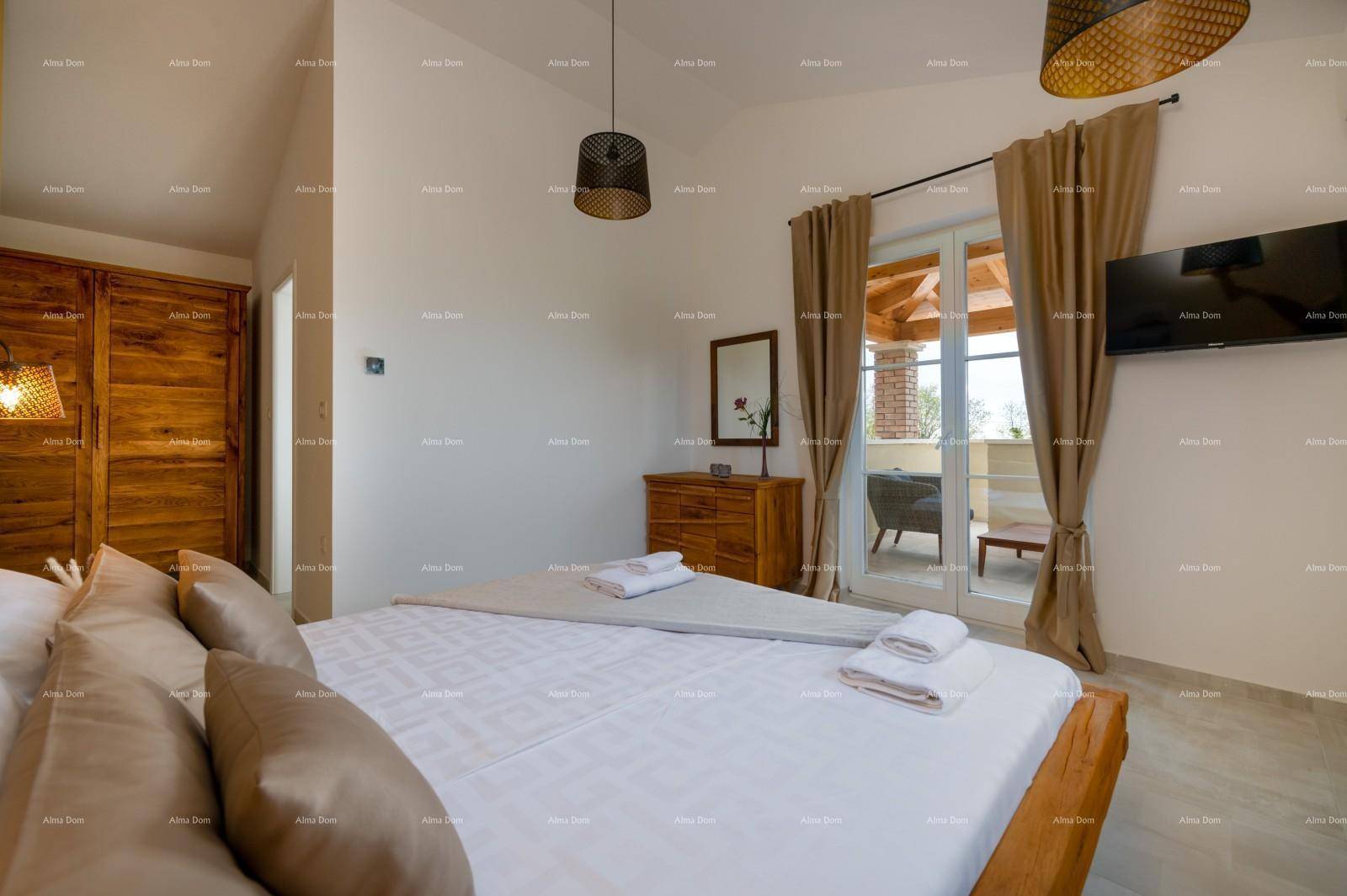 Schlafzimmer mit Holzbett, Kommode und direktem Zugang zum überdachten Balkon.