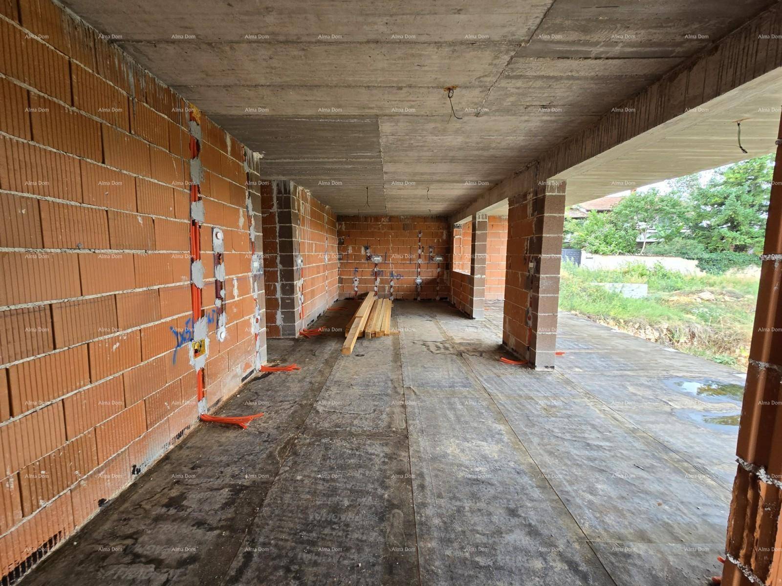 Langer Innenraum im Rohbau mit Ziegelwänden, Betonboden und vorbereiteten Elektroinstallationen.