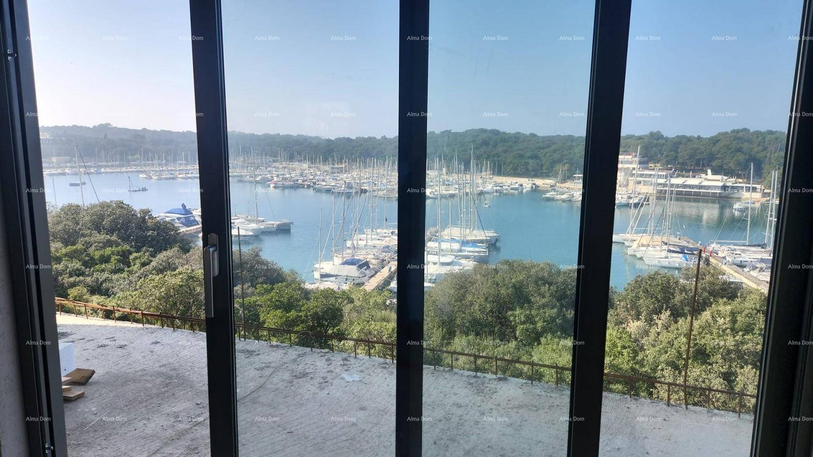 Heller Raum im Rohbau mit großen Glasschiebetüren und Panoramablick auf den Yachthafen.