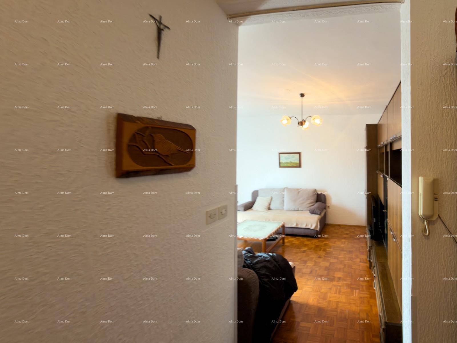 Wohnzimmer mit Parkettboden, Sofa und Blick in den angrenzenden Flur.