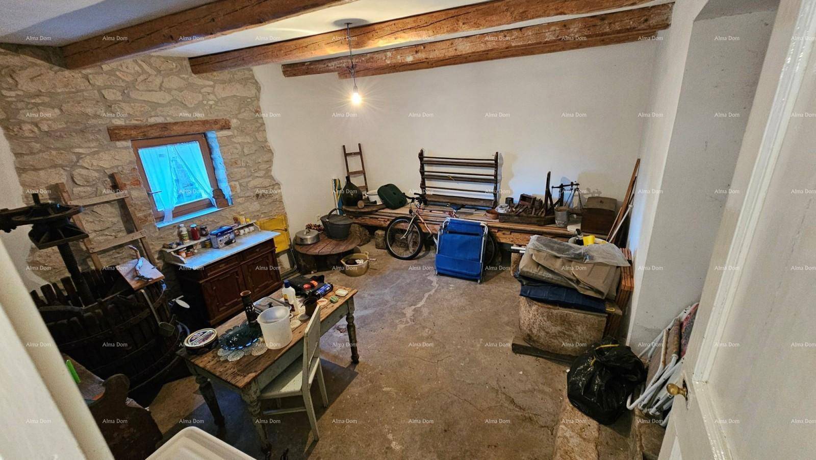 Rustikaler Abstellraum mit freiliegender Steinwand, Holzbalkendecke und verschiedenen Gegenständen.